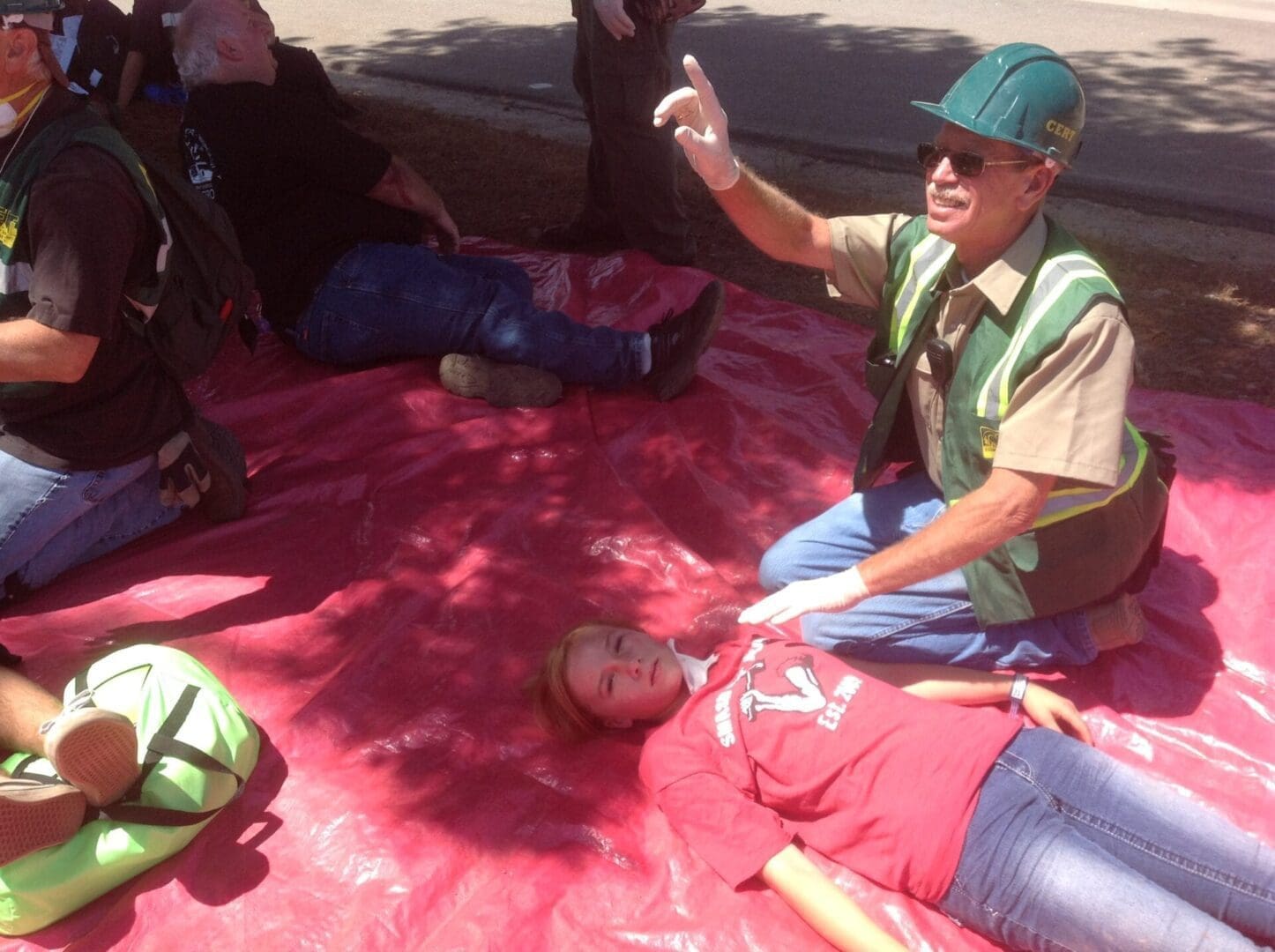A man sitting on the ground with his hands up.